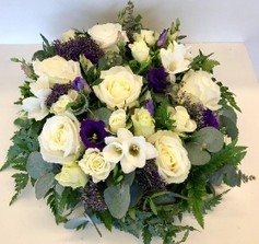 Violet and white funeral posy with mixed seasonal flowers and eucalyptus foliage for a fresh, natural finish